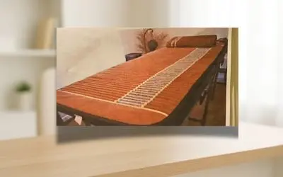 Manta Biomat posicionada sobre maca para sessão de terapia térmica com infravermelho e pedras