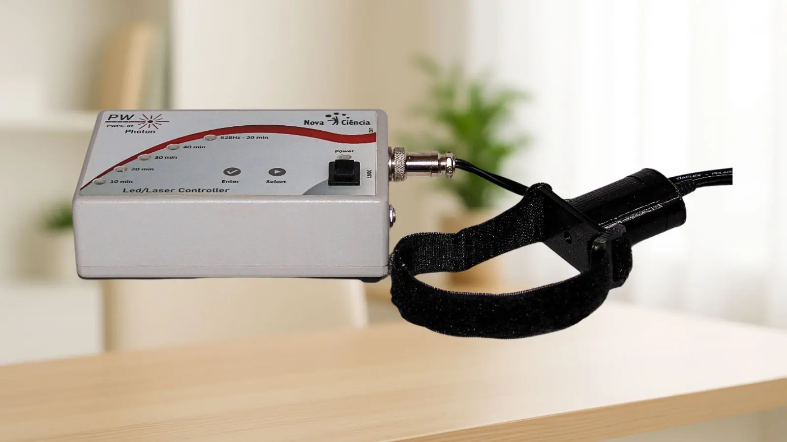 Dispositivo de ILIB sobre mesa com emissor de luz preso à pulseira de aplicação.